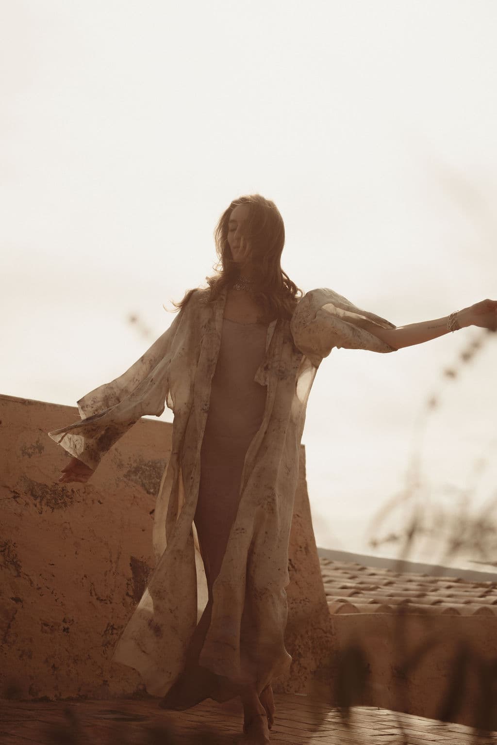 Woman in a flowing kimono dancing freely on a rooftop