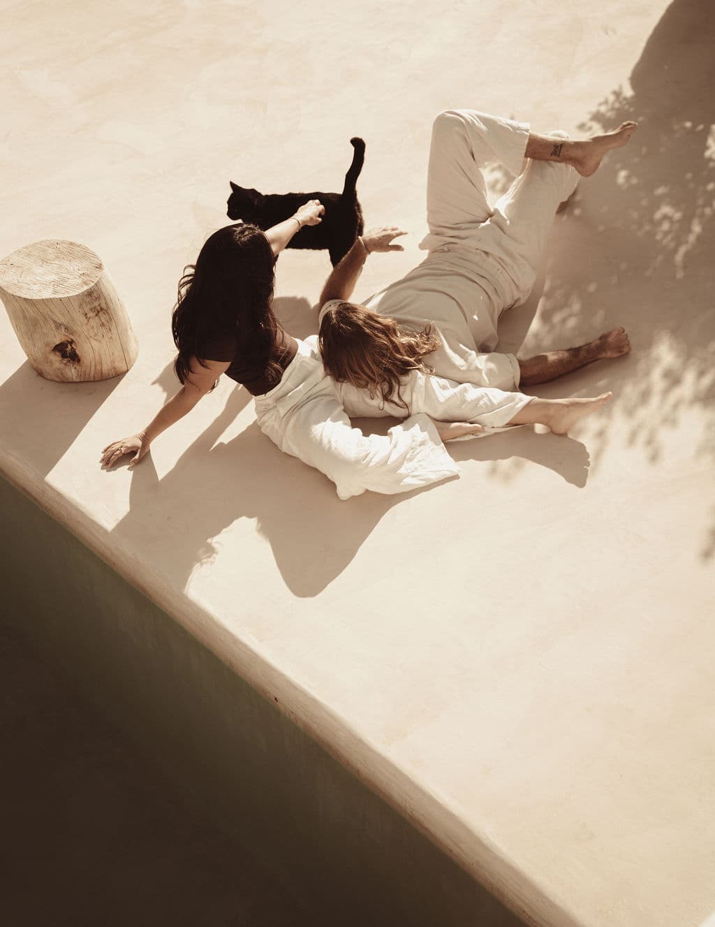 Couple playing with a black cat, relaxed and joyful