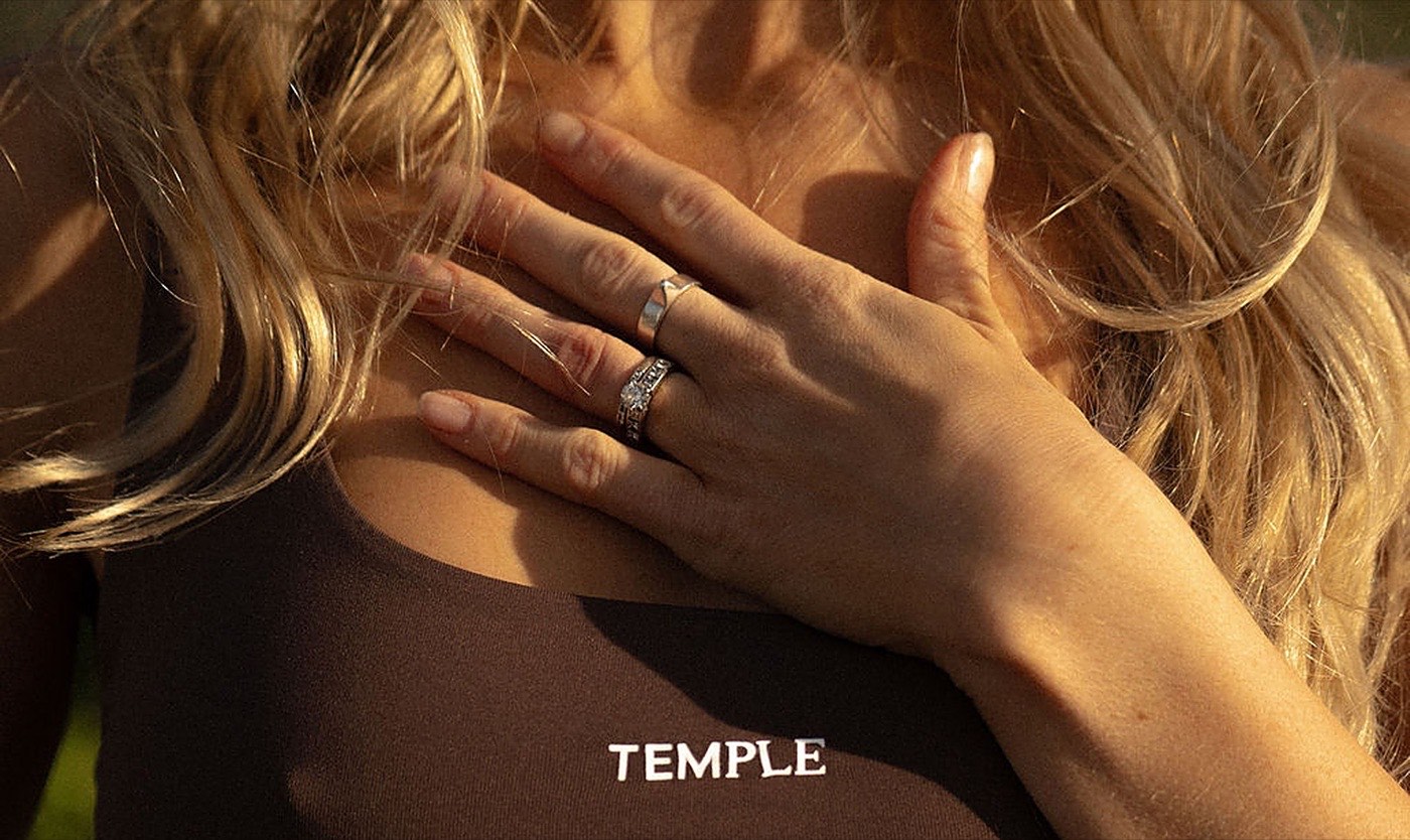 Frau legt in warmem Licht eine Hand auf ihre Brust und hört darauf, was der Körper über geringe Libido bei Frauen sagt | My Temple