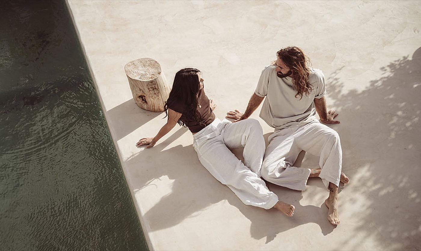 A couple sitting close in conversation on a sunlit terrace, connection at the heart of intimacy education | My Temple