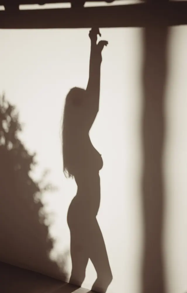 Silhouette einer Frau, die sich nach oben ins Licht streckt